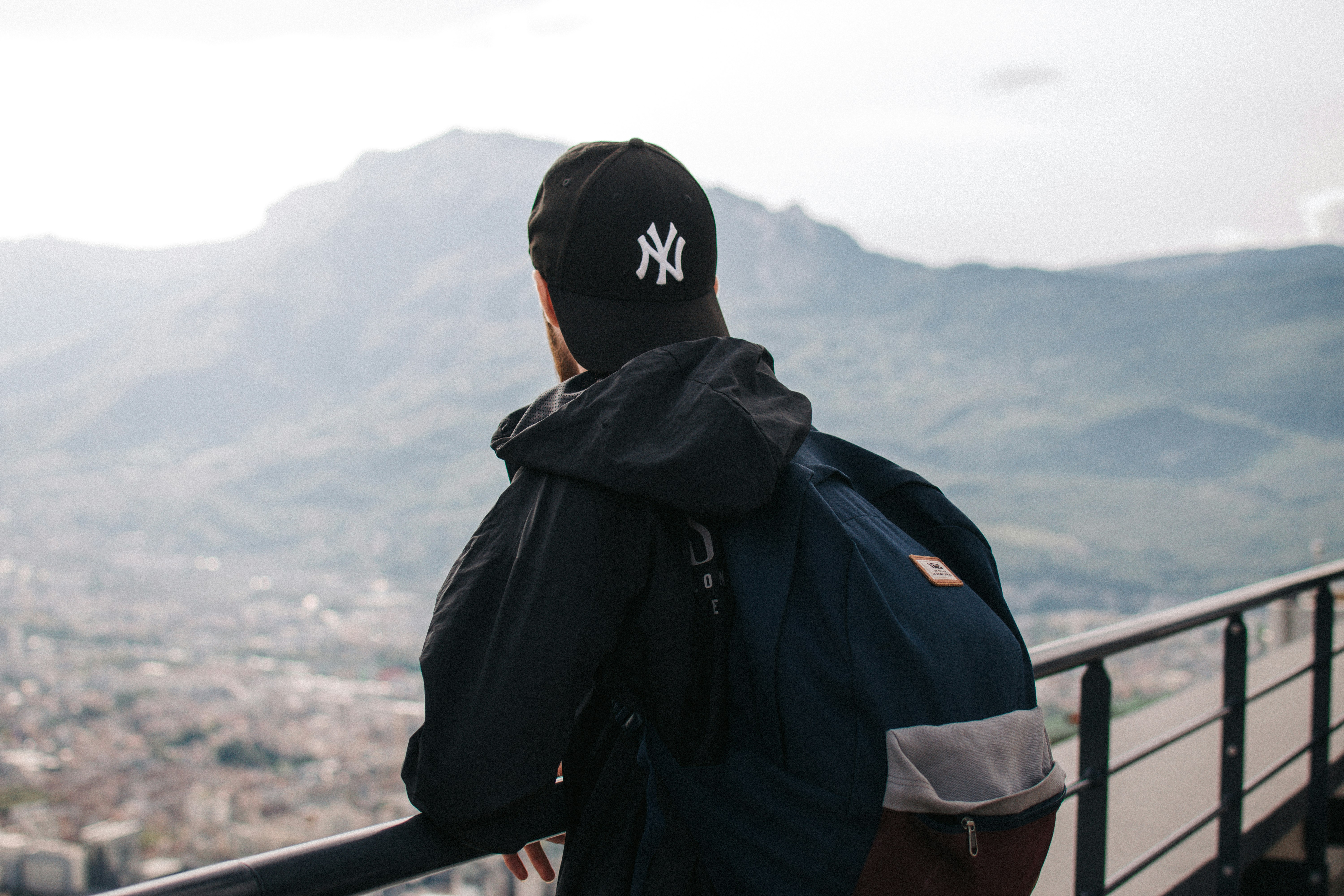 man in black hoodie wearing black and white cap